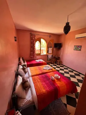 a bedroom with two beds and a checkered floor at Maison d´hôtes Amazir in Ouzoud