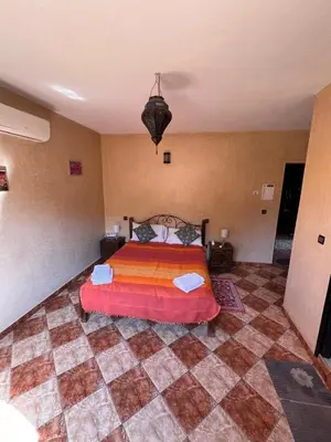 a bedroom with a bed and a checkered floor at Maison d´hôtes Amazir in Ouzoud