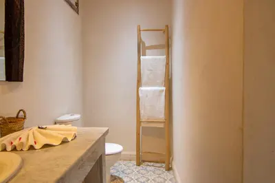 a bathroom with a toilet and a towel rack at Villa avec piscine chauffée Eden Marrakchi in Marrakech