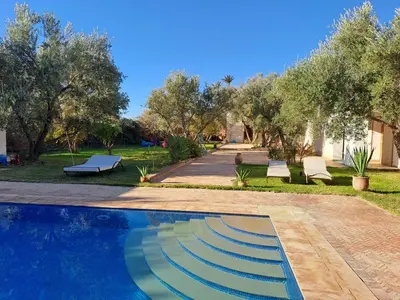 a swimming pool in a yard with trees at Villa avec piscine chauffée Eden Marrakchi in Marrakech