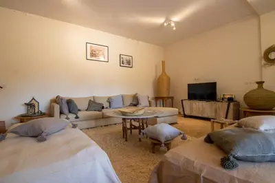 a living room with two beds and a couch at Villa avec piscine chauffée Eden Marrakchi in Marrakech