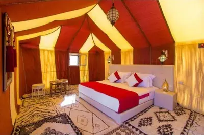 a bedroom with a large bed in a room at Desert Night Luxury Camp in Merzouga