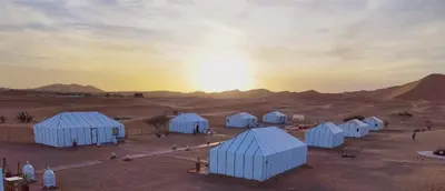 a group of white buildings in the desert at Desert Night Luxury Camp in Merzouga