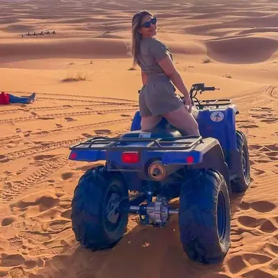 a woman sitting on a four wheeler in the desert at Desert Night Luxury Camp in Merzouga