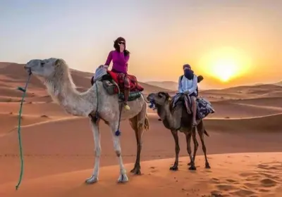 two people riding on the camel in the desert at Diamond luxury camp in Merzouga