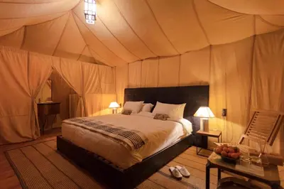 a bedroom with a bed in a tent at Camp Ayour luxury in Merzouga