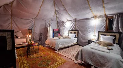 a bedroom with two beds in a tent at Camp Ayour luxury in Merzouga