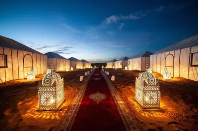 a row of buildings with lights on the ground at Camp Ayour luxury in Merzouga