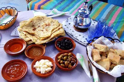 a table with plates of food and bowls of dips at Camp Ayour luxury in Merzouga
