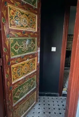 a wooden door with designs on it in a room at Riad Tilal Fes & spa in Fès