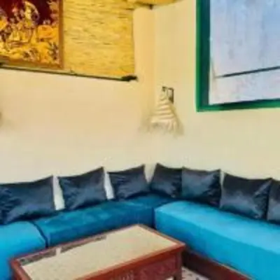 a blue couch in a living room with a coffee table at Riad Tilal Fes & spa in Fès