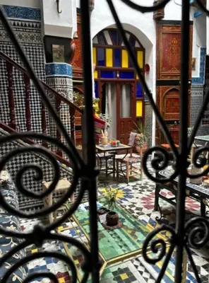 a view of a patio from a wrought iron fence at Riad Tilal Fes & spa in Fès