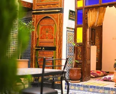 a table and chairs in a room with a door at Riad Tilal Fes & spa in Fès