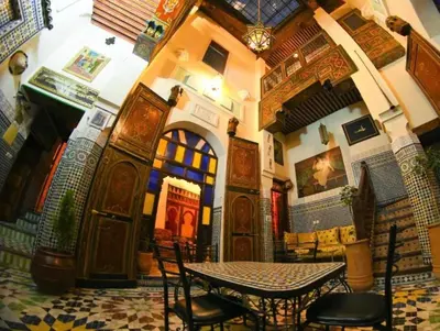 a room with a table and chairs in a building at Riad Tilal Fes & spa in Fès