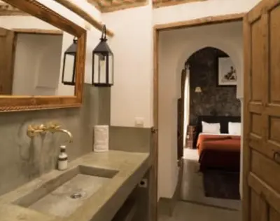 a bathroom with a sink and a bedroom with a bed at Riad Tilal Fes & spa in Fès