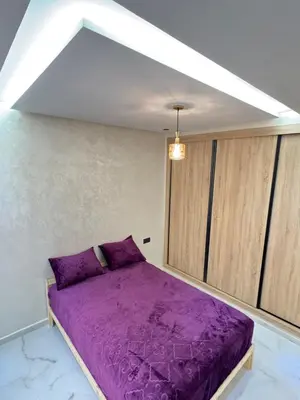 a bedroom with a purple bed in a room at Fes shore listings in Fès