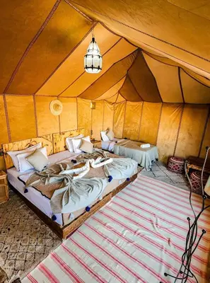 a bedroom with two beds in a tent at Merzouga Spectacular Luxury Camp in Merzouga