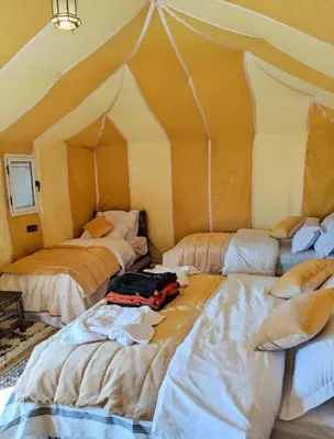 a room with three beds in a tent at Merzouga Spectacular Luxury Camp in Merzouga
