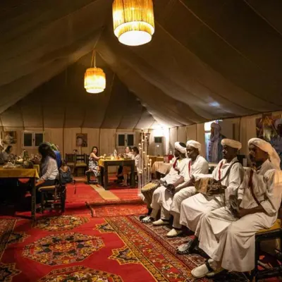 a group of men sitting in a tent at Merzouga Spectacular Luxury Camp in Merzouga