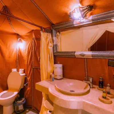 a bathroom with a toilet and a sink in a tent at Merzouga Spectacular Luxury Camp in Merzouga
