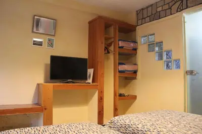 a bedroom with a bed and a desk with a television at Gîte rural à Jnane Imass in Jnane Imes