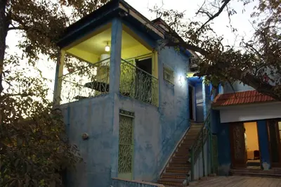 a blue house with a balcony and stairs at Gîte rural à Jnane Imass in Jnane Imes