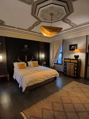 a bedroom with a large bed and a ceiling at Dar HISANE in Marrakech