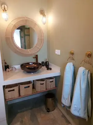 a bathroom with a sink and a mirror and baskets at Dar HISANE in Marrakech