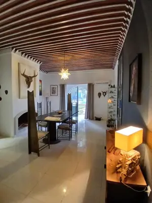 a dining room with a wooden ceiling and a table at Dar HISANE in Marrakech