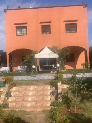 a large brick building with a white tent in front of it at Pool villa in Ourika in Ourika
