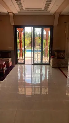 an empty room with doors open to a pool at Pool villa in Ourika in Ourika