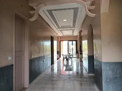 a hallway with a table and chairs in a building at Pool villa in Ourika in Ourika
