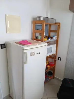 a small kitchen with a white refrigerator in a room at Appartement neuf équipé à Fez in Fès