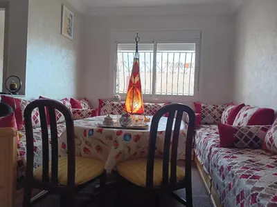 a living room with a table and a couch at Appartement neuf équipé à Fez in Fès