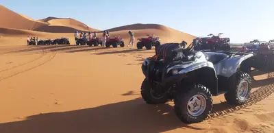 an atv parked in the sand in the desert at Merzouga Erg Luxury Camp in Merzouga