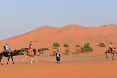 a group of people riding horses in the desert at Merzouga Erg Luxury Camp in Merzouga
