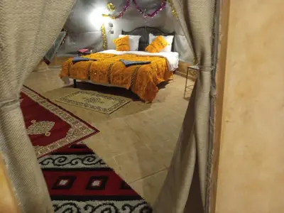 a view of a bedroom with a bed with yellow pillows at Merzouga Erg Luxury Camp in Merzouga