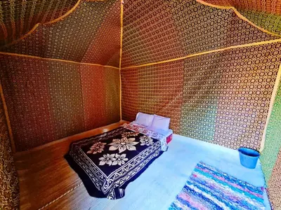 a small room with a small bed in a wall at Hami desert camping in Merzouga