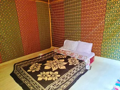 a bedroom with a bed with a patterned wall at Hami desert camping in Merzouga