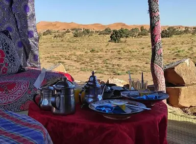 a table with food and pots and pans on it at Hami desert camping in Merzouga