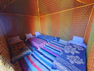 a room with two beds and a blanket at Hami desert camping in Merzouga