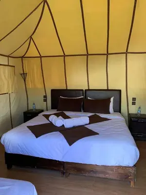 a bedroom with a large bed in a tent at Merzouga campsite in Merzouga