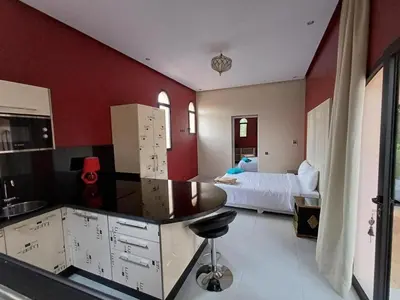 a bedroom with a bed and a kitchen with a counter at Villa Michel Lucas in Marrakech