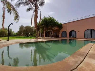 a swimming pool in front of a building at Villa Michel Lucas in Marrakech