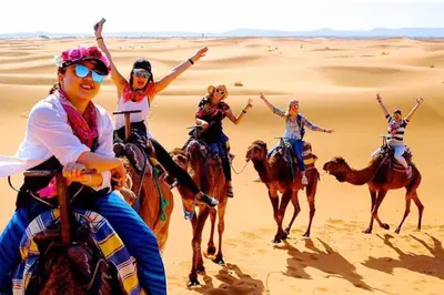 a group of people riding horses in the desert at Erg Chebbi Luxury Package & Activities in Merzouga