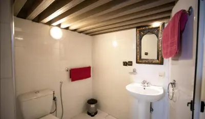 a bathroom with a sink and a toilet and a mirror at Dar Fez Mayssae in Fès