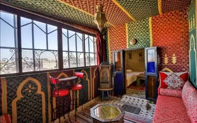 a room with a couch and a table and windows at Dar Fez Mayssae in Fès