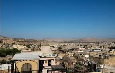 a view of a city with buildings and mountains at Dar Fez Mayssae in Fès