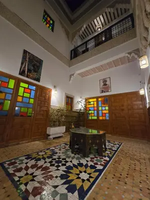 a room with a table and stained glass windows at Riad Sidi in Fès