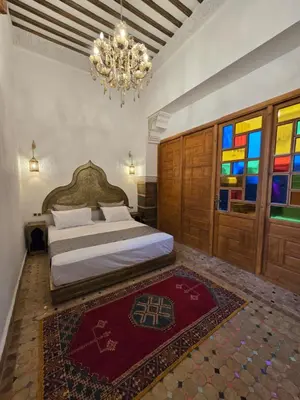 a bedroom with a bed and a chandelier at Riad Sidi in Fès